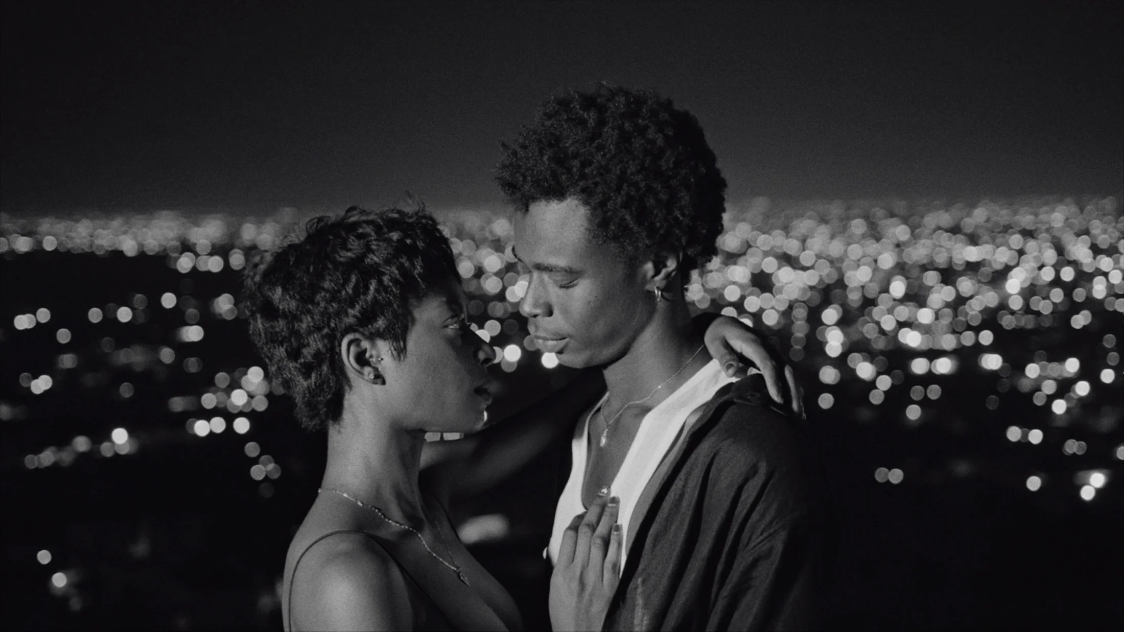 A couple sharing an intimate moment against distant city lights