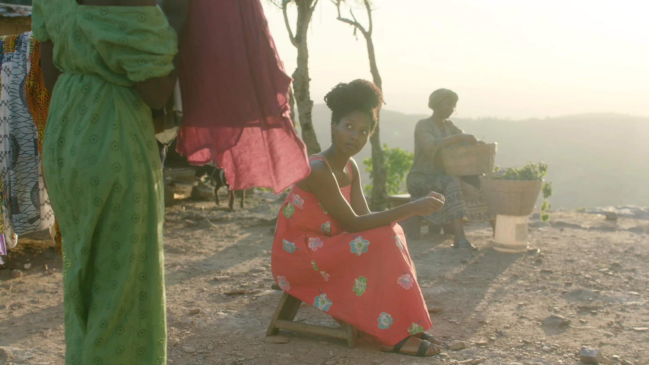 Women in colourful clothing gathered outdoors on a hillside