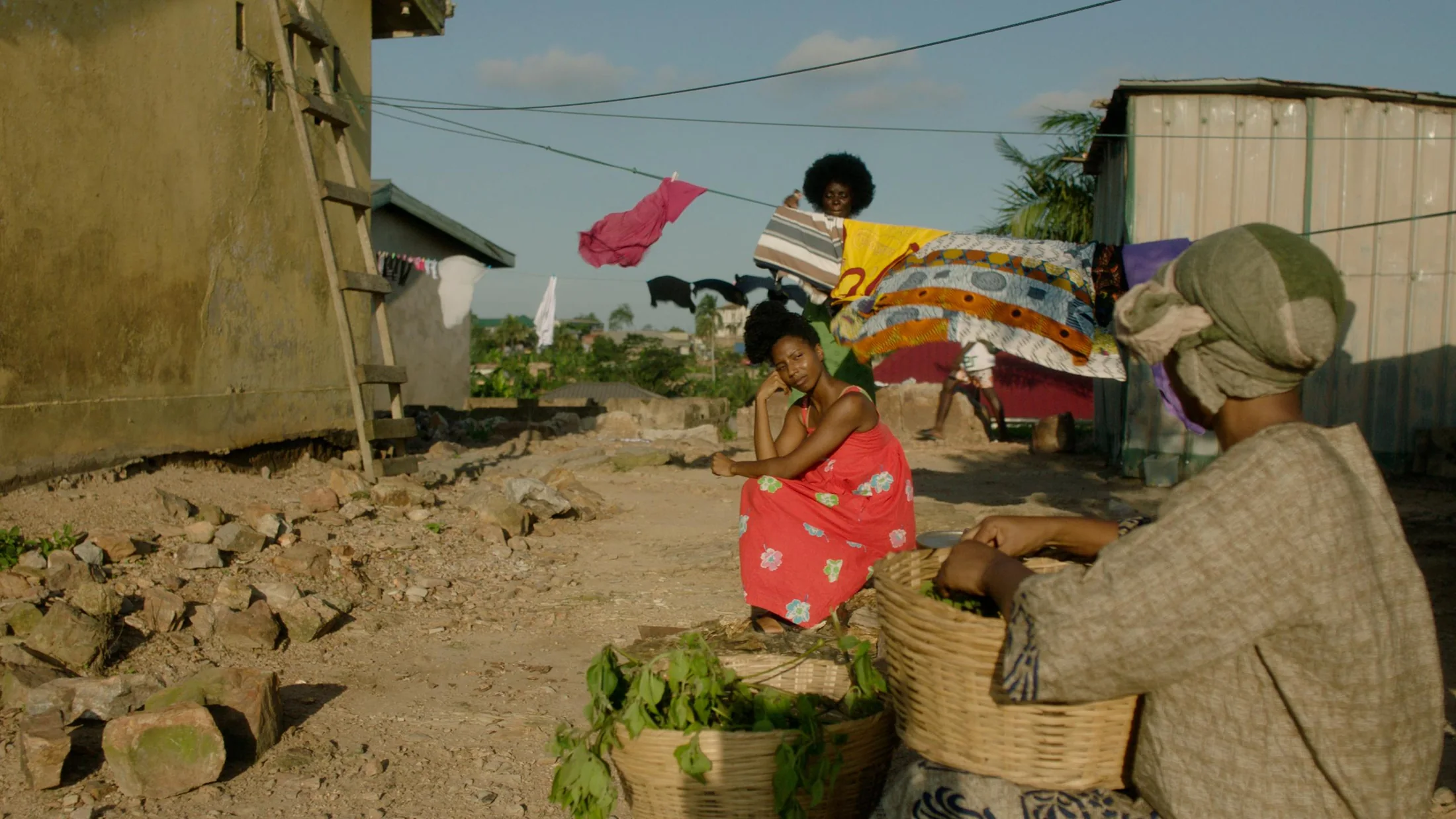 Women gathered beside a roadside market in warm afternoon light